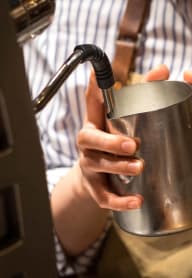 a man holding a metal cup with a handle