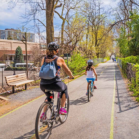 a woman and a child riding bikes on a bike path
