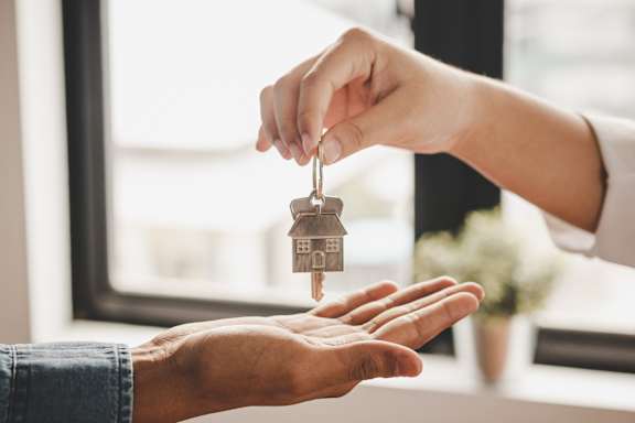 A person is handing over a key to another person.