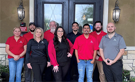 a group of people wearing red shirts standing in front of a house