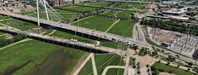 A large white bridge spans over a green field.
