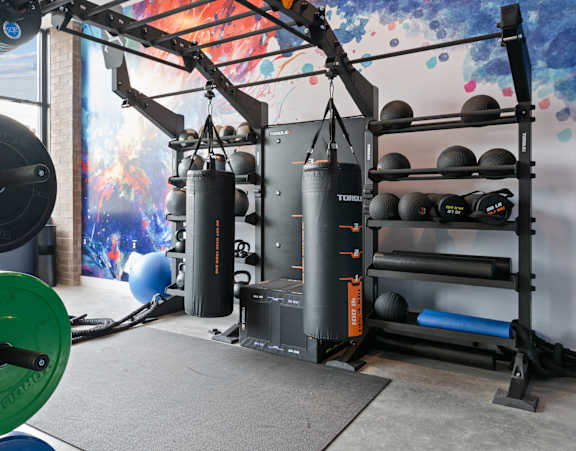 A gym with a weightlifting machine and a wall mural.