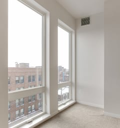 A bedroom with two large windows and a carpeted floor at Mercantile on Broadway, Fargo, North Dakota 58102