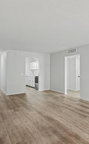 A room with wooden flooring and white walls.