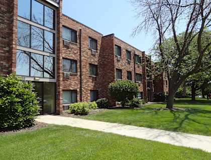 A brick building with a green lawn in front.