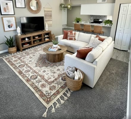 A living room with a white couch, a rug, and a ceiling fan.