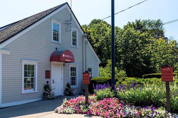 a white church with a flower garden in front of it