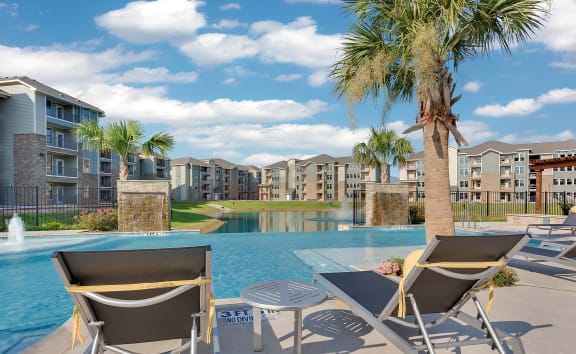 the preserve at ballantyne commons community swimming pool with lounge chairs and palm trees