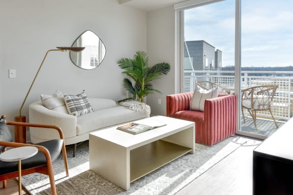 a living room with a white couch and a chair and a large window