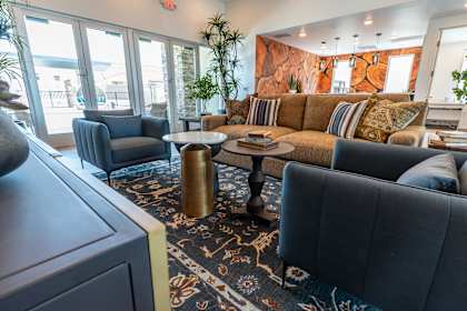 A living room with a grey couch and a blue armchair.