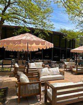 A patio with wooden furniture and umbrellas.