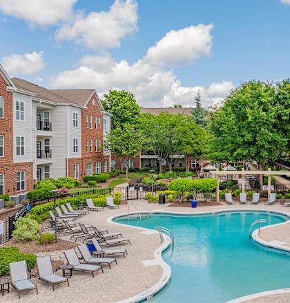 A large swimming pool surrounded by lounge chairs and umbrellas.