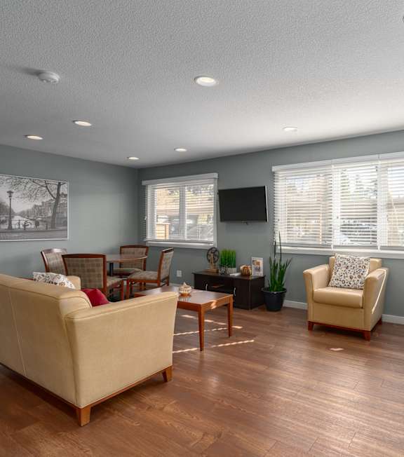 A living room with a beige couch, two chairs, and a coffee table.