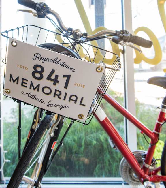 A red bicycle with a sign that says 847 Memorial.