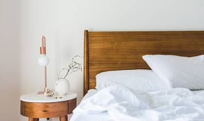 A bed with white pillows and a wooden headboard.