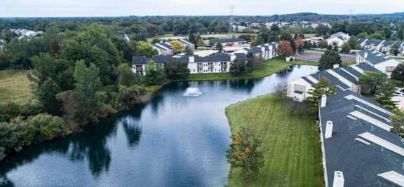 Lake surrounded by houses on both sides at Hidden Lakes Apartments, Michigan