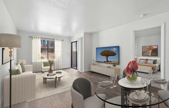 A dining room with a table set for two and a couch.