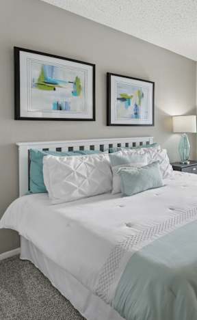 A bedroom with a bed, dresser, and two wall lamps.