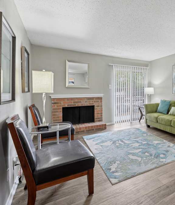 A living room with a fireplace and a green couch.