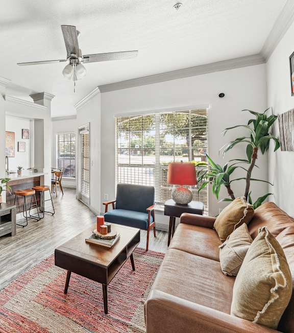 A living room with a wooden floor and a large window.