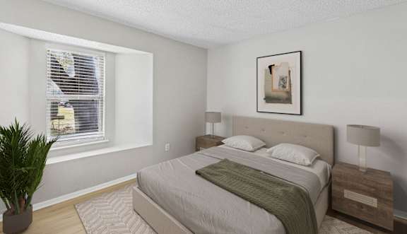 A bedroom with a bed, chair, and painting on the wall.