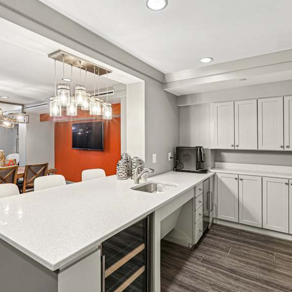 A modern kitchen with a white countertop and grey cabinets.