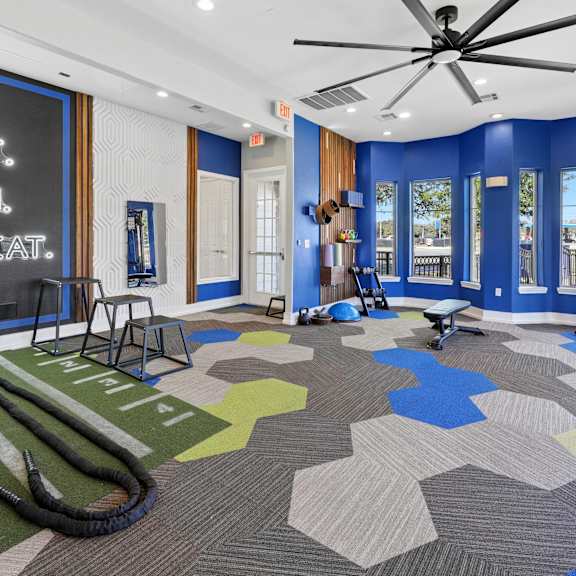 A gym with a blue wall and a sign that says "Lift. Run. Repeat."
