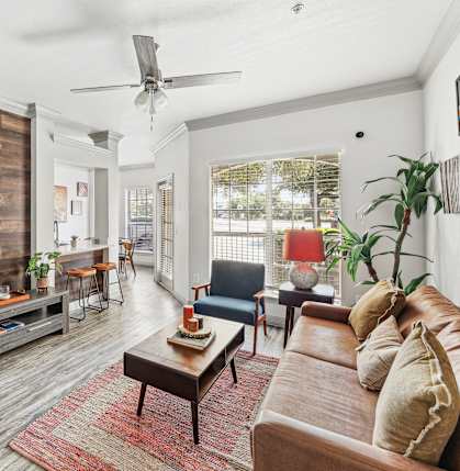 A living room with a wooden floor and a large window.