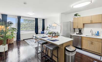 A kitchen with a table and chairs in front of a window.