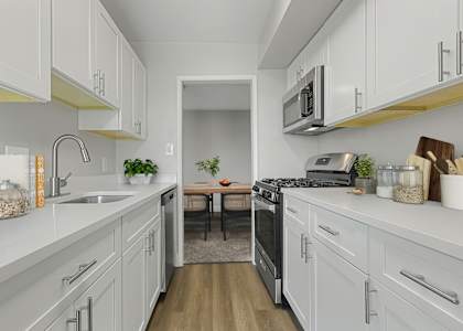 a kitchen with white cabinets and stainless steel appliances at Courthouse Square Apartments, Towson, 21286