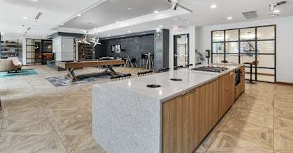 a large living room with a kitchen and a ping pong table