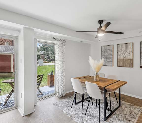 A dining room with a table and chairs and a ceiling fan.