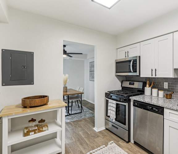 A modern kitchen with stainless steel appliances and white cabinets.