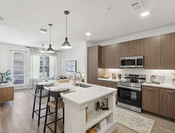 A modern kitchen with a white island and stainless steel appliances.