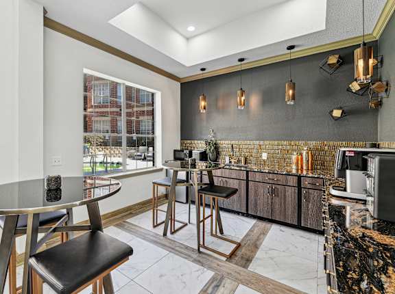 A modern kitchen with a round table and bar stools.