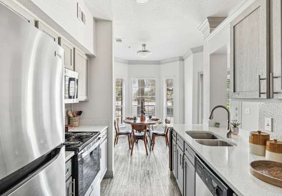 A modern kitchen with a large island and stainless steel appliances.
