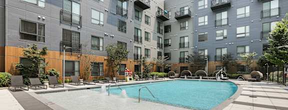 a swimming pool with an apartment building in the background