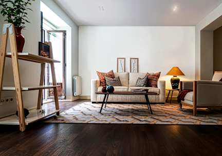 A living room with a white couch and a wooden floor.