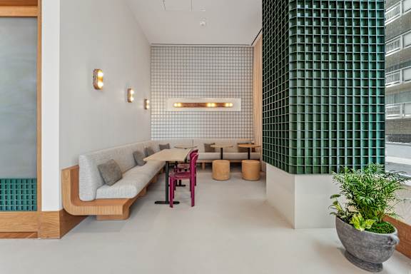 A modern living room with a long couch and a green wall.