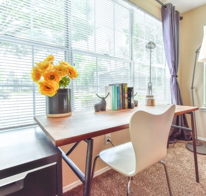 a desk with a chair and a lamp in front of a window at Riverset Apartments in Mud Island, Memphis, TN