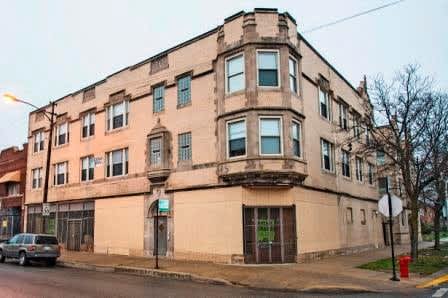 a building on the corner of a street with a car