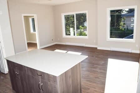 A room with a white counter and wooden cabinets.