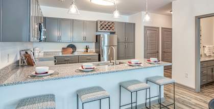 A kitchen with a bar stool and a counter.