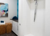 Thumbnail 18 of 19 - a walk in closet with white cabinets and a white bench with an umbrella on it