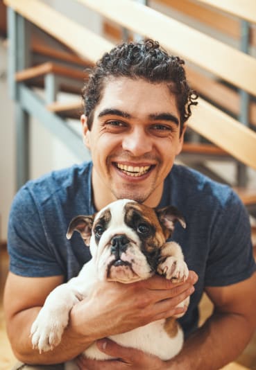 a man holding a dog at Illumina Apartment Homes in Seattle, WA