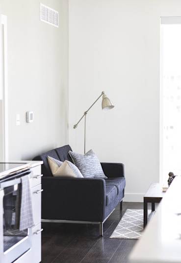 a living room with a couch and a lamp in it