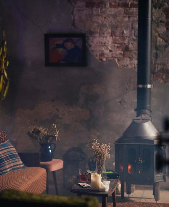 A cozy living room with a fireplace and a couch.