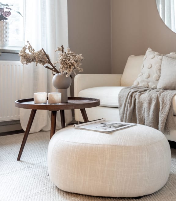 a living room with a white couch and a table with a vase on it at Willow Bend Apartments, Durham
