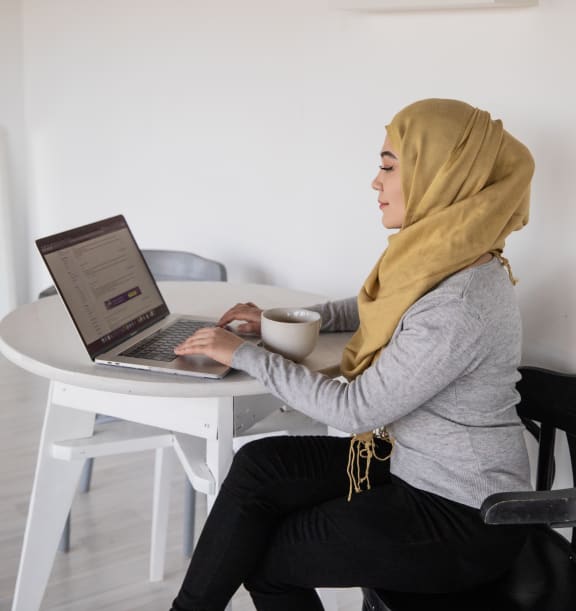 a woman sitting at a table with a laptop