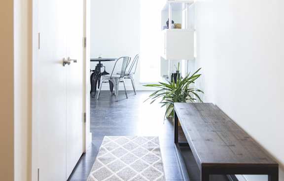 a living room with a table and a wooden bench
